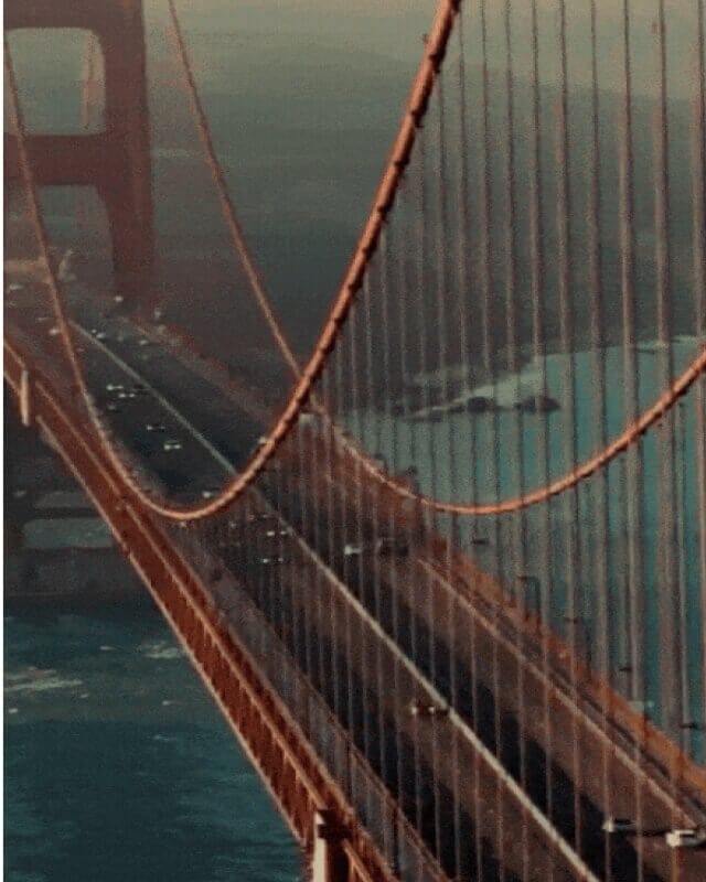 CrawlSF 63 Aerial view of the Golden Gate Bridge spanning San Francisco Bay, showcasing the iconic suspension bridge and surrounding coastal waters.
