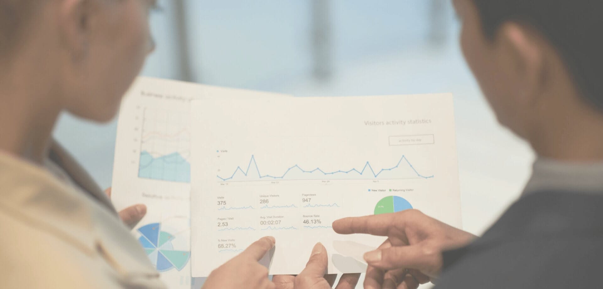 Two professionals reviewing website analytics and performance reports, analyzing visitor activity, engagement metrics, and business insights from data dashboards.