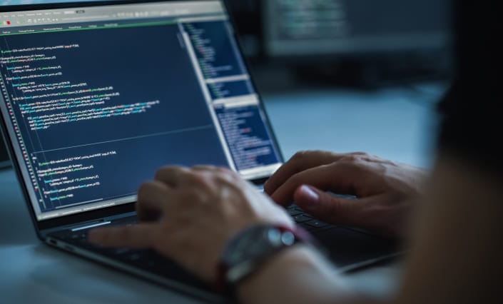 Person coding on a laptop