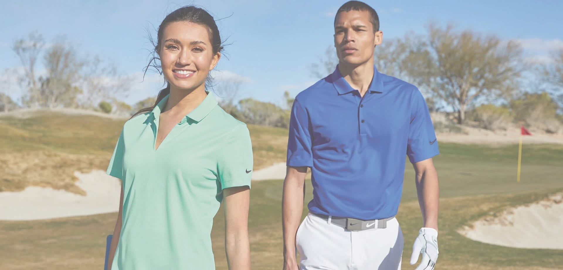 Two golfers in stylish apparel outdoors.