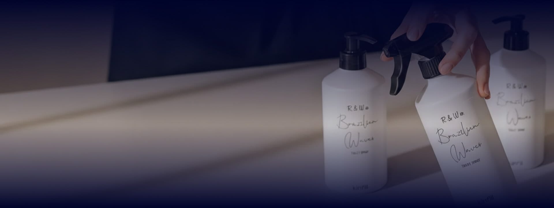 Close-up lifestyle image of R&W Co. cleaning products arranged on a countertop, featuring minimalist white packaging and a luxury home care aesthetic.