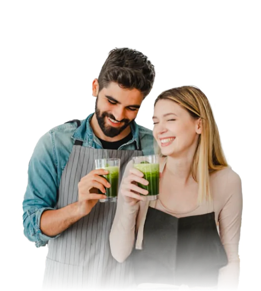 Smiling couple holding green drinks.