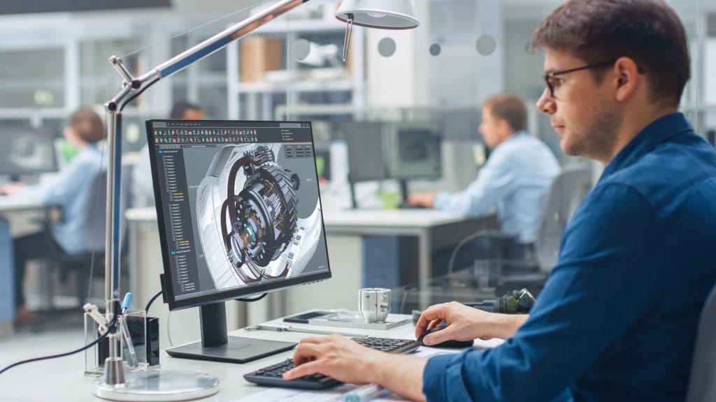 Tec5 USA 69 An engineer works at a computer displaying a 3D mechanical design in a modern office workspace